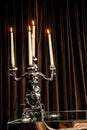 Silver candle holderwith candles lit on a table. Royalty Free Stock Photo