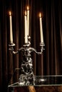 Silver candle holderwith candles lit on a table. Royalty Free Stock Photo