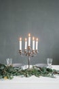 Silver chandelier with burning candles on the table Royalty Free Stock Photo