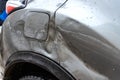 Silver car after the accident, broken door, fender and fuel tank close-up. Car accident close-up Royalty Free Stock Photo