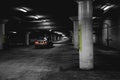 Silver car in a dark dirty parking place underground