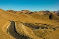 Silver car drives down a switchback road running across the Tibetan Plateau. Royalty Free Stock Photo