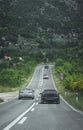 Silver car overtaking a slower black one on a straight before a corner. Dangeour overtake in forbidden area, possibility of Royalty Free Stock Photo