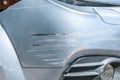 Silver car with scratched paint with red lines of other vehicle damaged in crash accident or parking lot, close up Royalty Free Stock Photo