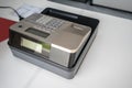 Silver cash register on white counter. Portable model cashing machine