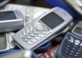 Silver cell phone in pile of others. Royalty Free Stock Photo