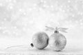 Silver Christmas balls with ribbon on white spakles bokeh background, Christmas background