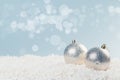 Silver Christmas balls in white snow on a blue background with bokeh lights. happy new year card Royalty Free Stock Photo