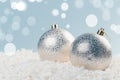 Silver Christmas balls in white snow on a blue background with bokeh lights. happy new year card Royalty Free Stock Photo