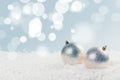 Silver Christmas balls in white snow on a blue background with bokeh lights. happy new year card Royalty Free Stock Photo