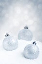 Silver Christmas baubles on snow with a silver background Royalty Free Stock Photo