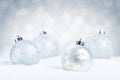Silver Christmas baubles on snow with a silver background Royalty Free Stock Photo