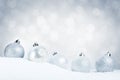 Silver Christmas baubles on snow with a silver background Royalty Free Stock Photo