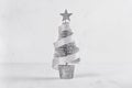 Silver christmas tree on white shabby plaster and wood background.