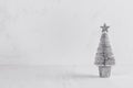 Silver christmas tree on white shabby plaster and wood board.