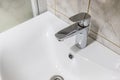 Silver clean shiny faucet on white sink Royalty Free Stock Photo