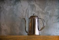 Silver coffee pots on shelf for home interior.