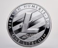 Silver coin of digital crypto currency with the symbol of Litecoin on a white background, close-up, macro