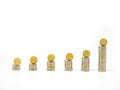 Silver coin stacks of different high with top with gold coin standing on edge. Frontal view. Royalty Free Stock Photo