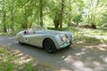 Silver color Jaguar XK120 Alloy classic car from 1949 driving on a country road