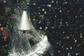 Silver colored bell on Christmas tree by night on background of snowing. Retro style Royalty Free Stock Photo