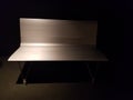 Silver colored metal bench half in the dark Royalty Free Stock Photo