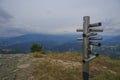 Silver-colored metal signpost in the mountains close-up across aerial mountains view. Adventure, travel lifestyle. Pietra di Bisma