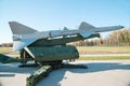 A silver-colored rocket with a launcher on the background of a forest and a blue sky. Military equipment planes missiles