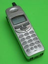 Silver cordless telephone on green backdrop Royalty Free Stock Photo