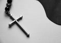 The silver cross on black and white paper background.