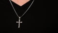 Silver crucifix or cross pendant and necklace on body or hand
