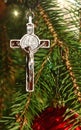 Body of Christ on real evergreen tree decorated with red bulbs