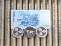 Silver crypto coins Ripple XRP, paper denominations Korean won. Metal coins are laid out in a smooth background to each other, clo