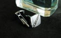 Silver cufflinks next to the perfume Royalty Free Stock Photo