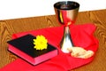 Silver cup , bread, bible on red background