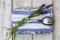 Silver cutlery and a blue-white kitchen towel with Lavender flower isolated on a wooden surface Royalty Free Stock Photo