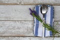 Silver cutlery and a blue-white kitchen towel with Lavender flower isolated on a wooden surface Royalty Free Stock Photo