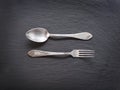 Silver cutlery on a grey background.