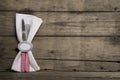 Silver cutlery in red and white checked with napkin on an old wooden background. Royalty Free Stock Photo