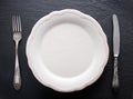 Silver cutlery and vintage plate on a grey background.