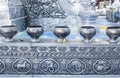 Silver donation bowls and some lit candles in Wat Sri Suphan Buddhist Temple. In Chiang Mai, Thailand