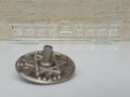 A silver dreidel on a white table with a glass chanukiah in the background Royalty Free Stock Photo