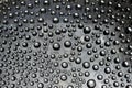 Silver drops flow down on the gray mirror ice surface. Close-up. Royalty Free Stock Photo