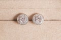 Silver earrings with diamonds macro shot on the brown background. Royalty Free Stock Photo