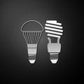 Silver Economical LED illuminated lightbulb and fluorescent light bulb icon isolated on black background. Save energy Royalty Free Stock Photo