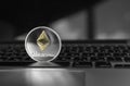 Silver Ethereum coin with gold Ethereum symbol on a laptop keyboard. Exchange, bussiness, commercial. Profit from mining