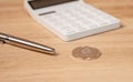 Silver etherium coin on wooden table with pen and calculator. Cryptocurrency in accounting concept