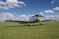 A silver fast plane at a grassy airport at an air show.