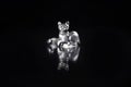 Silver finger ring figurine of lying cat on black mirror surface