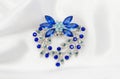 Silver flower brooch with blue diamonds on silk fabric Royalty Free Stock Photo